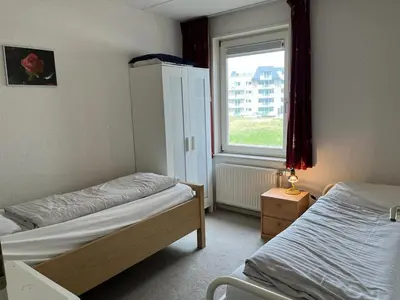 a bedroom with two beds and a window at Atlantis 14a in Egmond aan Zee