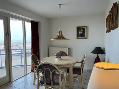 a dining room with a table and chairs and a window at Atlantis 14a in Egmond aan Zee