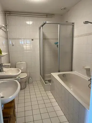 a bathroom with a shower and a tub and a toilet at Atlantis 14a in Egmond aan Zee