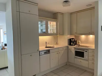 a kitchen with white cabinets and a sink at Atlantis 14a in Egmond aan Zee