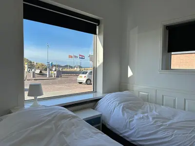 a bedroom with a bed and a window at Zin aan Zee in Egmond aan Zee