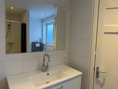 a bathroom with a sink and a mirror at Zin aan Zee in Egmond aan Zee