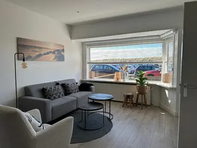 a living room with a couch and a table at Zin aan Zee in Egmond aan Zee