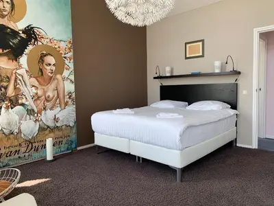 a bedroom with a bed with a poster on the wall at Heerlijke villa met zwembad en sauna bij het strand in Bergen aan Zee