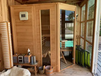a wooden shed with a door and a microwave at Heerlijke villa met zwembad en sauna bij het strand in Bergen aan Zee