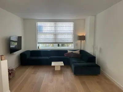 a living room with a green couch and a table at Spacious and lovely home in Amsterdam