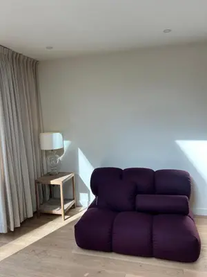 a purple couch in a living room with a lamp at Spacious and lovely home in Amsterdam