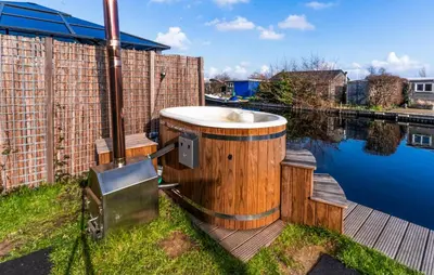 a wooden tub sitting on the side of a body of water at Gorgeous Home In Vinkeveen With Sauna in Vinkeveen