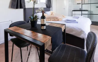 a bottle of wine sitting on a table next to a bed at Gorgeous Home In Vinkeveen With Sauna in Vinkeveen