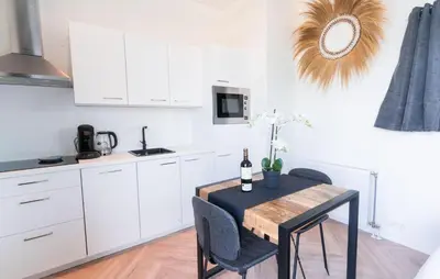 a kitchen with white cabinets and a table with a bottle of wine at Gorgeous Home In Vinkeveen With Sauna in Vinkeveen