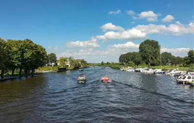 a group of boats floating down a river at Beautiful Home In Vinkeveen With Sauna in Vinkeveen