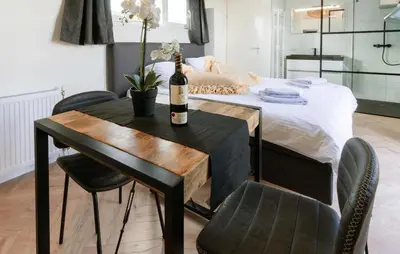 a bottle of wine on a table next to a bed at Beautiful Home In Vinkeveen With Sauna in Vinkeveen
