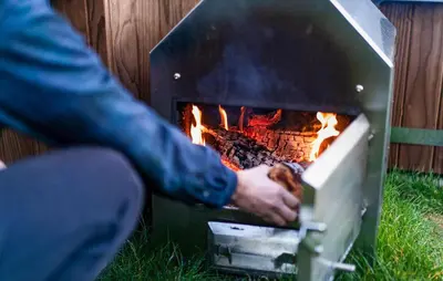 a person is cooking food in a fireplace at Beautiful Home In Vinkeveen With Sauna in Vinkeveen