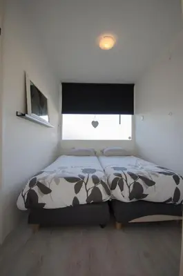 a bedroom with a bed and a window at Casa Luma in Zandvoort