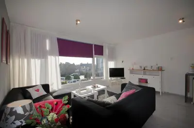 a living room with a couch and a large window at Casa Luma in Zandvoort