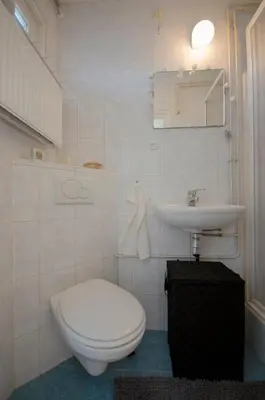 a white bathroom with a toilet and a sink at Casa Luma in Zandvoort