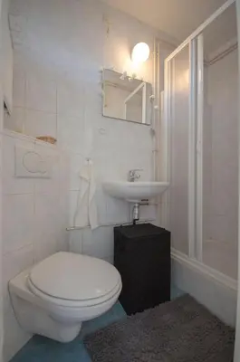 a white bathroom with a toilet and a sink at Casa Luma in Zandvoort