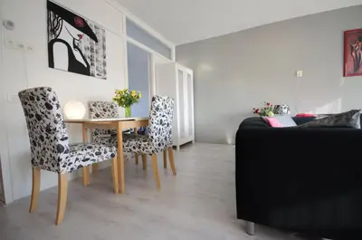 a living room with a table and chairs and a bed at Casa Luma in Zandvoort