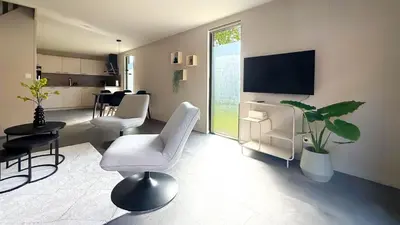 a living room with a chair and a tv at 't Boschhuys by Droomvilla in Bergen