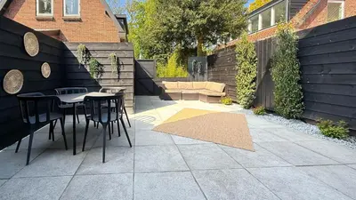a patio with a table and chairs in a backyard at 't Boschhuys by Droomvilla in Bergen