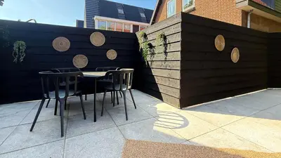 a table and chairs in front of a fence at 't Boschhuys by Droomvilla in Bergen