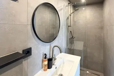 a bathroom with a sink and a mirror and a shower at 't Boschhuys by Droomvilla in Bergen