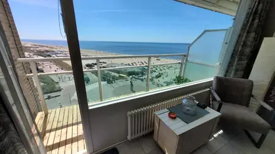 a balcony with a chair and a view of the beach at Aladdin's Sky in Zandvoort