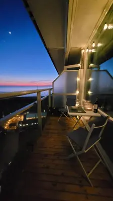 a table and chairs on a balcony at night at Aladdin's Sky in Zandvoort