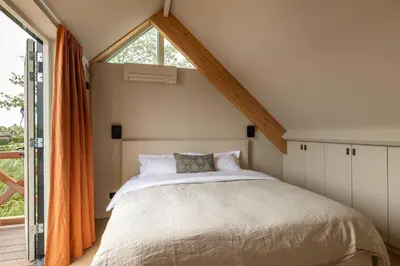 a bedroom with a bed and a large window at Guesthouse De Waterliefde Loosdrecht in Breukelen
