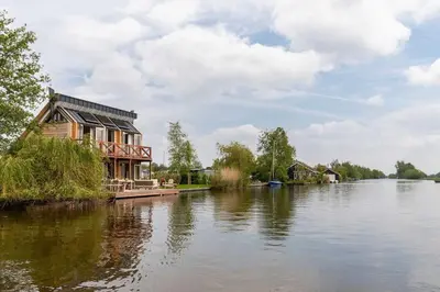 a house on the bank of a river at Guesthouse De Waterliefde Loosdrecht in Breukelen
