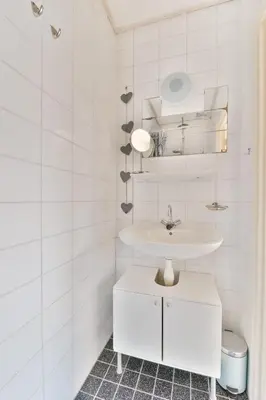 a white bathroom with a sink and a counter at Studio la Riet in Alkmaar