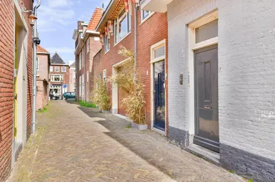an empty alley with brick buildings and a door at Studio la Riet in Alkmaar