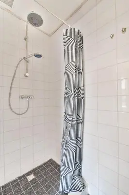 a shower with a black and white shower curtain at Studio la Riet in Alkmaar