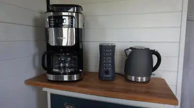 a coffeemaker and a coffee maker on a wooden shelf at Bed and Breakfast Het schapenlandje in Waarland