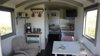 a small kitchen and dining room in a tiny house at Bed and Breakfast Het schapenlandje in Waarland