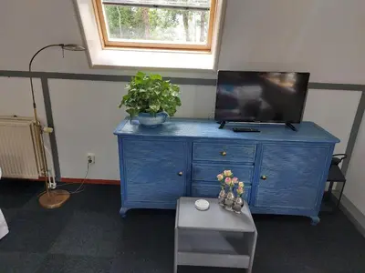 a blue dresser with a tv on top of it at Appartement De Molshoop in Landsmeer