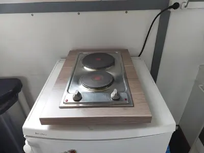 a stove top oven sitting on top of a refrigerator at Appartement De Molshoop in Landsmeer