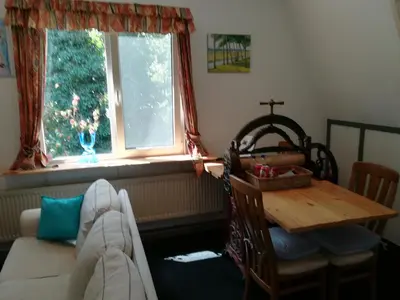 a living room with a table and a window at Appartement De Molshoop in Landsmeer