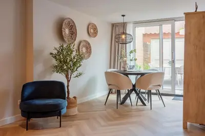 a dining room with a blue chair and a table at Short Stay Zandvoort at 68A in Zandvoort