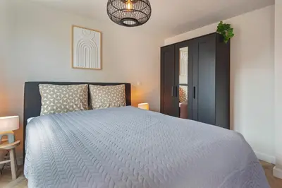 a bedroom with a bed with a blue comforter at Short Stay Zandvoort at 68A in Zandvoort