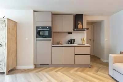 a small kitchen with white cabinets and a stove at Short Stay Zandvoort at 68A in Zandvoort