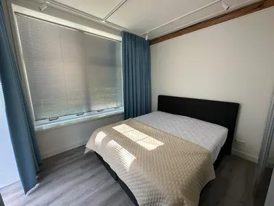 a small bedroom with a bed and a window at Golf course around the corner! in Nieuwveen