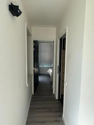 a hallway leading to a room with white walls and wood floors at Golf course around the corner! in Nieuwveen