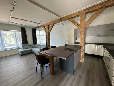 a kitchen and living room with a sink and a table at Golf course around the corner! in Nieuwveen
