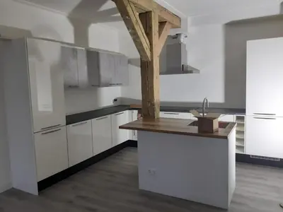 a kitchen with white cabinets and a wooden counter top at Golf course around the corner! in Nieuwveen