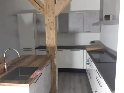 a kitchen with white cabinets and a wooden counter top at Golf course around the corner! in Nieuwveen