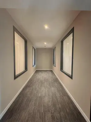 an empty hallway with two windows and a carpet at Nebula Hotel by Ine's in Assendelft