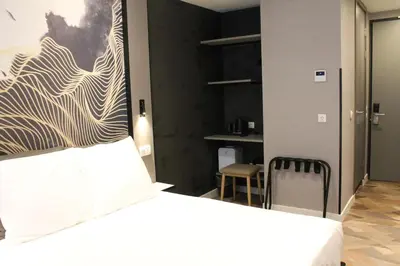 a bedroom with a bed and a table and a chair at Nebula Hotel by Ine's in Assendelft