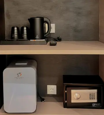 a microwave under a counter with a coffee pot on top at Nebula Hotel by Ine's in Assendelft