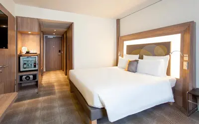 a bedroom with a large white bed and a television at Novotel Amsterdam Schiphol Airport in Hoofddorp